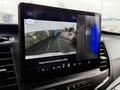 A dashboard display of a 2022 Ford Transit shows a rearview camera view with guidance lines and an overview of the vehicle's surroundings for parking assistance