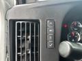 A close-up view of the control panel in a 2018 Chevrolet Express featuring buttons for lights, air conditioning, and a confirmation check mark