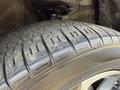 Close-up of the tire of a 2021 Toyota C-HR showing tread pattern and sidewall design with visible dirt and wear on the rubber surface