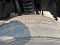 Close-up of a worn tire on a 2009 Ford F-550 showing visible tread wear and a damaged sidewall