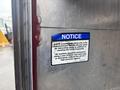 A notice sticker on a metallic surface advising the use of non-petroleum based silicone spray for lubricating parts and washing instructions with water and mild soap