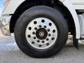 Close-up of a wheel from a 2008 Kenworth T370 featuring a silver rim with multiple holes and a black tire with tread visible