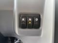 A gear shifter panel with three buttons labeled R N D and an illuminated indicator light