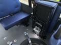 A folded wheelchair lift installed inside a 2020 Chevrolet Express van with blue upholstery on the seats
