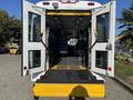 A 2017 Ford Transit-350 with rear doors open displaying an interior ramp and seating for passengers