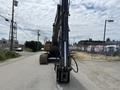 2018 John Deere 350 excavator facing forward with a large arm extended and tracks visible on the ground