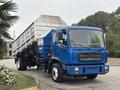 A blue 2017 Autocar Xpert truck with a large silver cargo bed and a flat front design parked on a road
