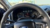 Steering wheel of a 2016 Ford F-150 with dashboard gauges visible and an information display indicating the gear selection