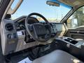 Interior of a 2008 Ford F-550 featuring a steering wheel dashboard controls and a center console with storage compartments