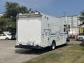 A white 2011 Workhorse W62 delivery truck with a solid rear door and side compartments parked in a lot