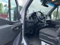 Interior of a 2025 Mercedes-Benz Sprinter showing the driver's seat steering wheel and dashboard with a focus on the controls and seating design