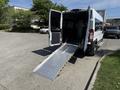 A 2021 RAM Promaster van with its back doors open and a metal ramp extended down to the ground