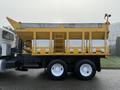A 2016 International 7400 truck with a yellow and gray dump bed featuring multiple compartments for materials and a ladder on the side