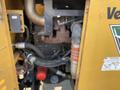 A close-up view of a 2010 Vermeer Corporation BC1200XL industrial wood chipper engine showcasing various components including pipes and a red cap
