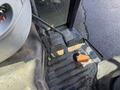 Foot pedals of a 2010 New Holland T4050 tractor showing two pedals for acceleration and braking with an orange cover for the transmission control