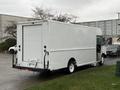 A white 2018 Ford E-450 box truck parked with its rear doors closed and no visible branding