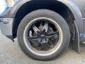 A close-up of a black alloy wheel on a 2017 RAM 1500 showcasing a five-spoke design with chrome accents and all-terrain tires