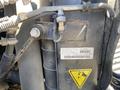 Close-up view of a metal component from a 2014 International TerraStar showcasing various pipes, wires, and a warning label with an illustration
