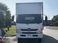 A 2018 Hino 195 truck with a white cab and a boxy cargo area at the rear visible headlights and side mirrors without any markings or logos