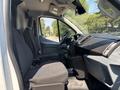 The interior of a 2019 Ford Transit 350 showing two front seats with fabric upholstery and a dashboard with controls and a steering wheel
