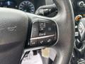 Close-up of the steering wheel of a 2020 Ford Transit 250 featuring control buttons for phone, audio, and settings