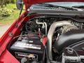 Image shows the engine compartment of a 2007 Ford F-550 with a visible battery labeled Magnacharge and various components including hoses and tubes