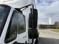 A 2014 International TerraStar truck showing the side mirror and part of the cab with a white box truck body attached
