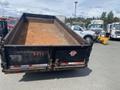 A 2009 Load 16 foot Dump Trailer with a rusty bed and black exterior showing the rear structure and branding on the tailgate