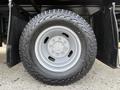 A close-up of a 2015 Ford F-350 tire mounted on a silver wheel with a rugged tread pattern