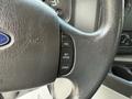 Close-up of the steering wheel of a 2013 Ford Econoline featuring control buttons for cruise control