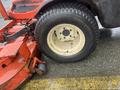 A close-up of a wheel from a 2010 Kubota F3680 featuring a thick black tire with a white rim attached to a red mower deck