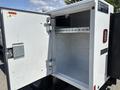 A white 2021 RAM 5500 with an open utility box featuring interior shelving and a well-lit storage space