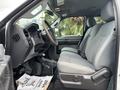 Interior view of a 2013 Ford F-250 SD showing a driver seat and steering wheel with a gray fabric and vinyl upholstery
