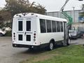 A white 2021 Ford Transit-350 with a rear entry and large windows displaying safety notices such as "KEEP BACK," "5 METRES," and "LIFT DEPLOYS FROM REAR"