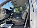 Interior of a 2004 Ford F-750 featuring a driver seat steering wheel and dashboard with a simple design and leather seat upholstery