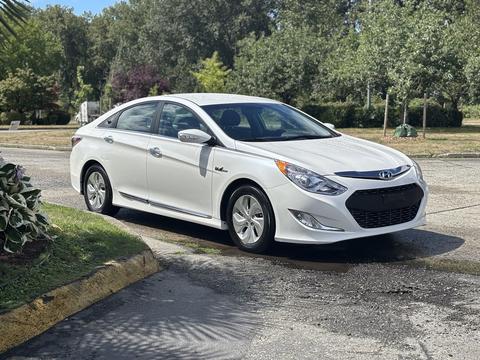 A 2014 Hyundai Sonata in white color parked with its doors closed and wheels on the ground