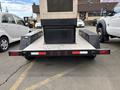 A black 2005 Katolight SED60FPJ4 generator trailer with a flatbed design and an enclosed storage compartment in the center