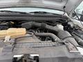 2004 Ford F-350 SD engine compartment featuring various components including an air intake hose and coolant reservoir