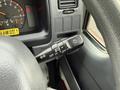 A close-up view of the steering column of a 2001 Toyota Dyna featuring the turn signal and headlight control stalks