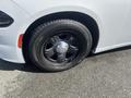 A close-up of a black wheel and tire on a 2017 Dodge Charger showcasing a chrome hubcap and detailed tire tread