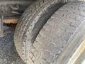 Close-up of large, worn tires on a 1997 Freightliner FL70 showcasing distinct tread patterns and rugged textures