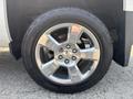 A close-up of a shiny silver alloy wheel from a 2017 Chevrolet Silverado 1500 showcasing a five-spoke design and a high-traction tire