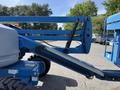 A 2012 Genie Z 45/25 aerial work platform featuring a blue boom with a hydraulic arm and a grappling attachment for elevated tasks