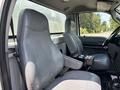 Interior of a 2015 Ford F-750 featuring two gray leather seats with armrests and a central console with controls
