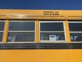 A yellow 2006 Thomas Saf-T-Liner HDX school bus with windows and an emergency exit sign in English and French