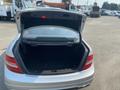A 2013 Mercedes-Benz C-Class with an open trunk, showing a spacious interior without any items inside