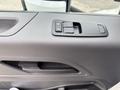 A close-up of a door panel from a 2025 Peterbilt 536 featuring window control buttons and an interior door handle