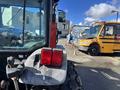 A 2010 New Holland T4050 tractor with a distinct red rear light mounted on the back and a steering wheel visible inside the cabin