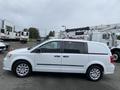 A white 2014 RAM Cargo Van parked with a side view showcasing its sleek design and alloy wheels