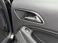 Close-up of the door handle and control panel of a 2016 Mercedes-Benz GLA-250 with leather detailing and metallic accents